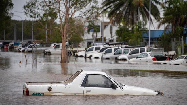 Cars amid floodwaters at Cairns Airport on Monday. Picture: Brian Cassey/AFP