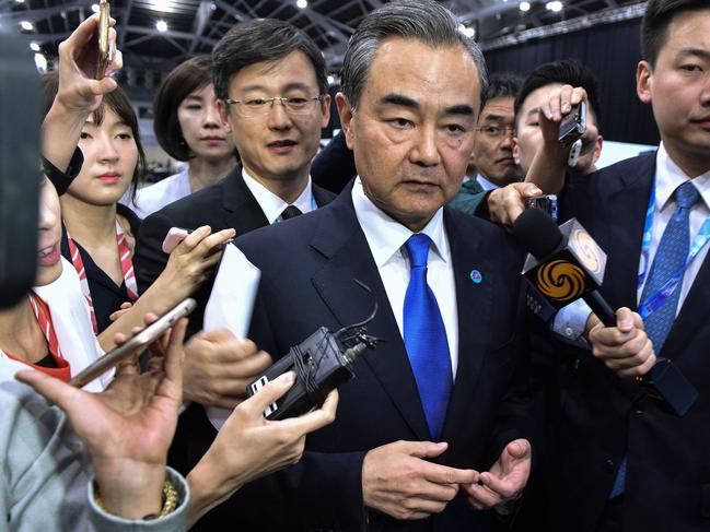 China's Foreign Minister Wang Yi (C) listens to questions from journalists as he leaves a press conference during the 51st Association of Southeast Asian Nations (ASEAN) in Singapore on August 2, 2018. Leaders, ministers and representatives are meeting in the city-state from August 1 to 4 for the ASEAN Ministerial Meeting (AMM). / AFP PHOTO / Mohd RASFAN