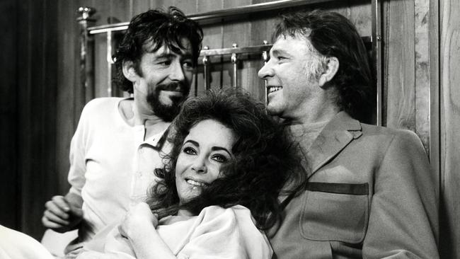 Richard Burton surprises co-stars Elizabeth Taylor and Peter O'Toole by joining them in bed for a photo opportunity, during the filming of a love scene for 'Under Milk Wood', in 1972.