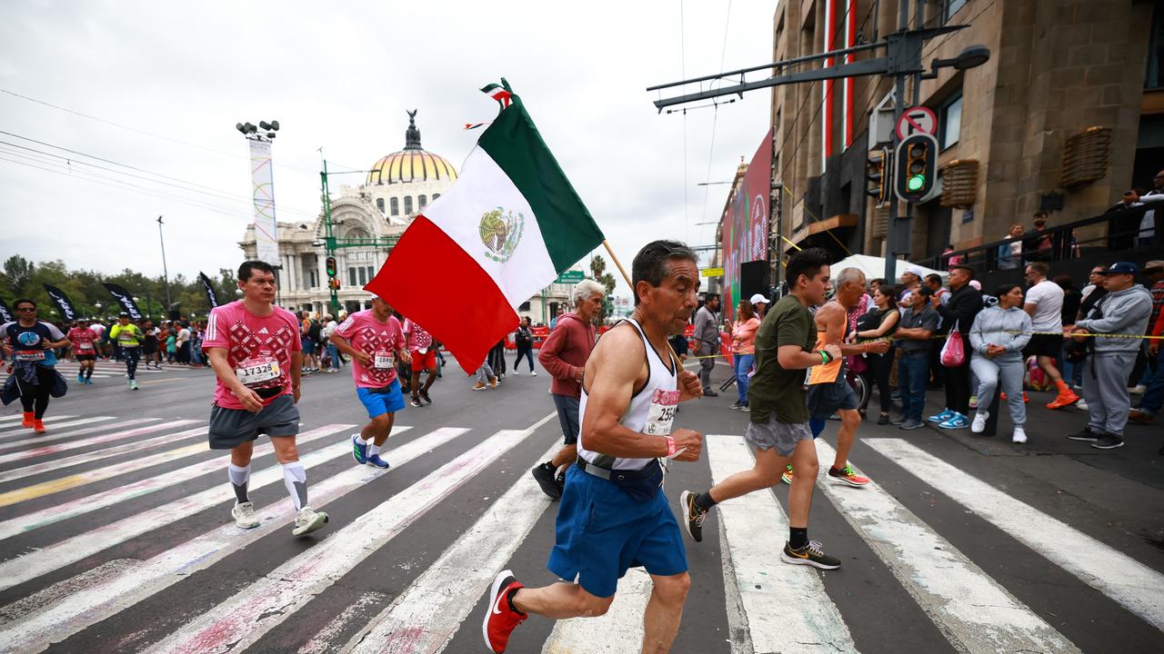 A runner competes with the Mexican flag. Photo by Hector Vivas/Getty Images