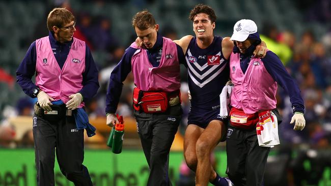 Alex Pearce is helped from the field. Picture: Getty Images