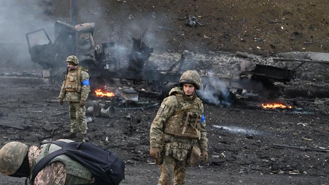 Ukrainian service members look for and collect unexploded shells after a fighting with Russian raiding group in the Ukrainian capital of Kyiv on February 26, 2022. Picture: Sergei Supinsky/AFP