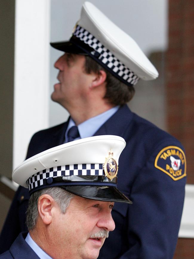 Senior Constable Victor Kubiak, front, and Constable John Gray leave the Burnie Supreme Court during Wright’s 2004 trial.