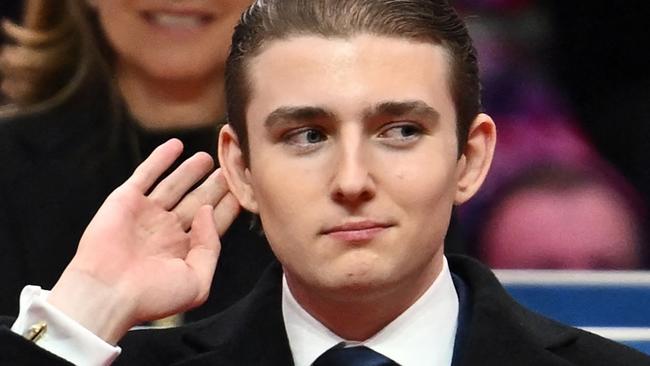 TOPSHOT - Barron Trump gestures after being acknowledged by his father US President Donald Trump during the inaugural parade inside Capital One Arena, in Washington, DC, on January 20, 2025. (Photo by ANGELA WEISS / AFP)