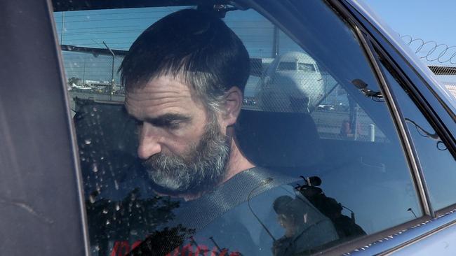 Matthew Tilley is seen with police leaving the Adelaide Airport on September 23, 2019, after being extradited from Victoria to face murder charges. Picture: AAP Image/Kelly Barnes