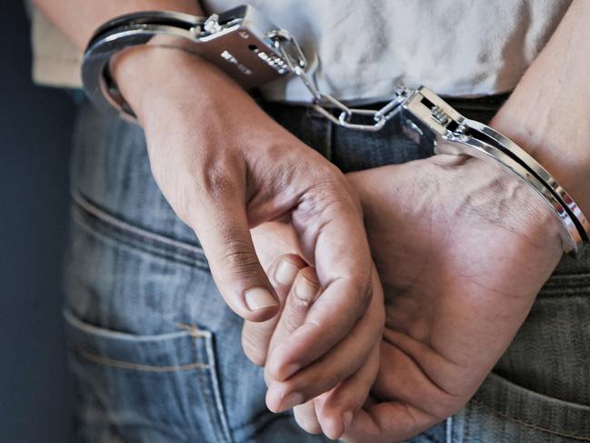 Young man in handcuffs stock image