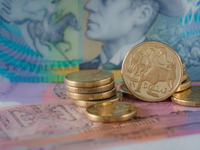 One and Two Dollar Coins Australian ten and five dollar notes in the background - Australian Currency; savings money notes generic