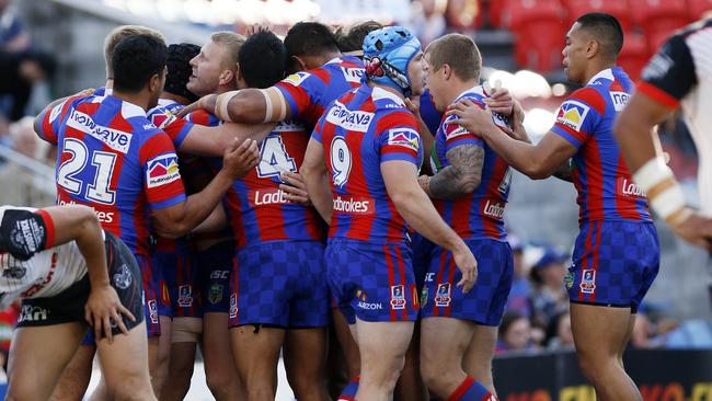 Knights players celebrate the first of two tries to Mitchell Barnett against the Warriors.