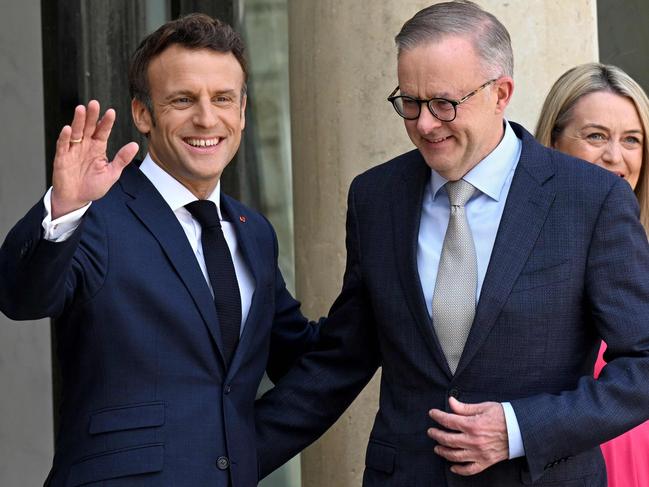 France's President Emmanuel Macron (L) waves as he welcomes Australia's Prime Minister Anthony Albanese (R) prior to a working lunch at the presidential Elysee Palace in Paris on July 1, 2022. (Photo by Emmanuel DUNAND / AFP)