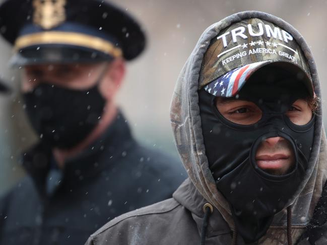 LANSING, MICHIGAN - JANUARY 17: Demonstrators protest outside of the Michigan state capitol building on January 17, 2021 in Lansing, Michigan. Supporters of President Trump gathered at state capital buildings throughout the nation today to protest the presidential election results and the upcoming inauguration of President-elect Joe Biden.   Scott Olson/Getty Images/AFP == FOR NEWSPAPERS, INTERNET, TELCOS & TELEVISION USE ONLY ==