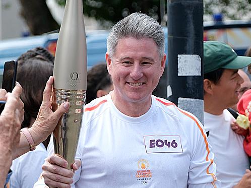 Nine CEO Mike Sneesby carries the Olympics torch in Paris. Picture: Jacquelin Magnay