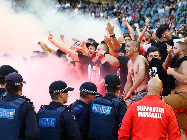 MELBOURNE, AUSTRALIA - FEBRUARY 06: Wanderers fans in the crowd let off flares as police officers look on during the round 18 A-League match between the Melbourne Victory and Western Sydney Wanderers at Etihad Stadium on February 6, 2016 in Melbourne, Australia. The FFA (Football Federation Australia) has fined the Western Sydney Wanderers $50,000 and given a suspended three-point A-League deduction after finding the club guilty of bringing the game into disrepute after 25 flares and detonators were set off during the match. (Photo by Scott Barbour/Getty Images)