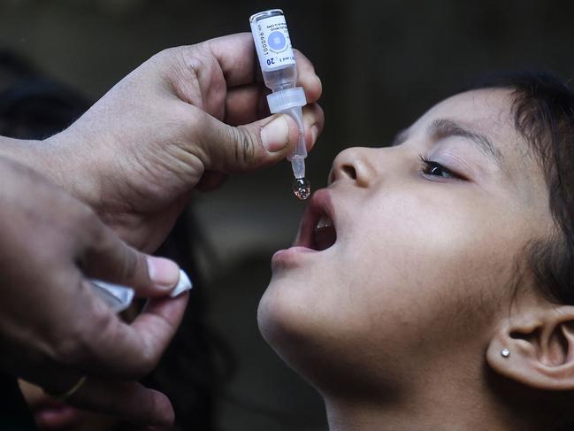 A health worker administers polio vaccine drops to a child during a polio vaccination campaign in Karachi, Pakistan. Picture: AFP