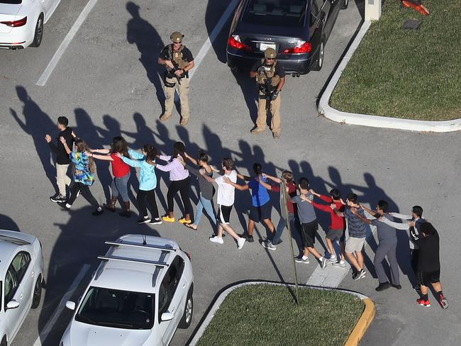 People are brought out of the Marjory Stoneman Douglas High School after a shooting at the school that reportedly killed and injured multiple people. Picture: Getty Images