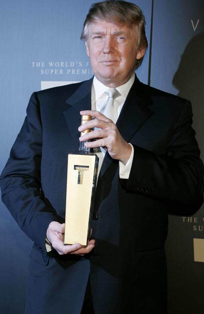 Donald Trump holds a bottle of his line of vodka as he arrives for the Trump Vodka launch party. Picture: AP