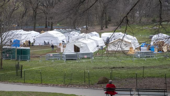 A woman watches from a park bench in Central Park as an emergency field hospital is built. Picture: Mary Altaffer/AFP