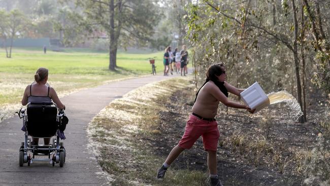 Fleur Rington and her 21-year-old son Dion helping to put out flames yesterday. Photo: Tim Marsden