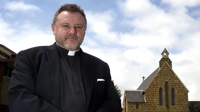 Father Rod Bower at Gosford Anglican Church with his sign about asylum seekers.pic Sue Graham