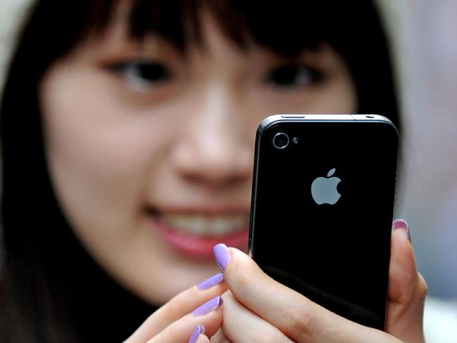 New purchase ... Sydney resident May Tong uses her new Apple iPhone 4 outside the main city store in 2010. Photo: AFP