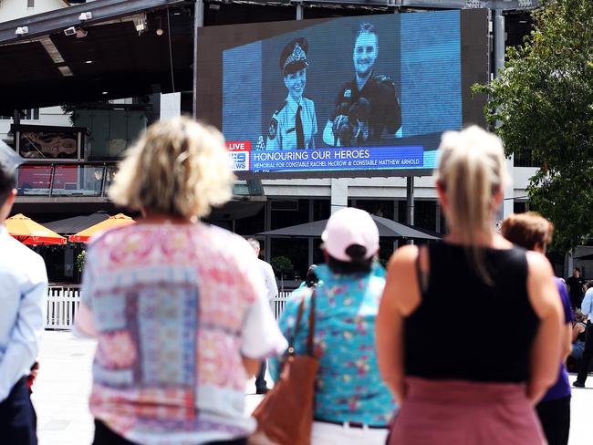 Members of the public watch the Queensland Police Memorial Service for Constable Rachel McCrow and Constable Matthew Arnold from King George Square. Picture: Zak Simmonds