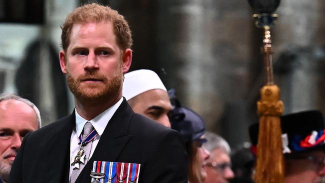 Did Harry feel a pang when he saw the other members of his family in their gowns and uniforms while he was dressed like any other civilian in a morning suit and medals? Picture: AFP