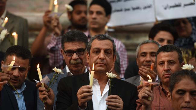 The head of the Egyptian journalists union, Yahiya Kallash (centre) stands among colleagues during a candle light vigil in memory of EgyptAir MS804 victims in Cairo. Picture: AFP/Mohamed El-Shahed