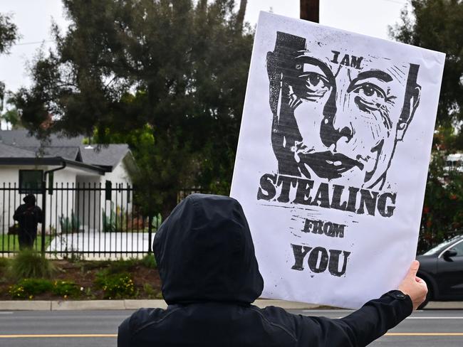 A protester holds a placard outside a Tesla dealership in Los Angeles, California. Picture: Frederic J. Brown / AFP