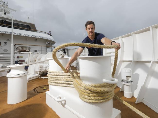 Coral Expeditions deckhand Mitch Patterson ties down rope on the cruise ship in dock at Cairns International Passenger Terminal. Picture by Sean Davey.