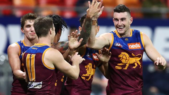 Lions players swamp McStay after a goal. Pic: AAP