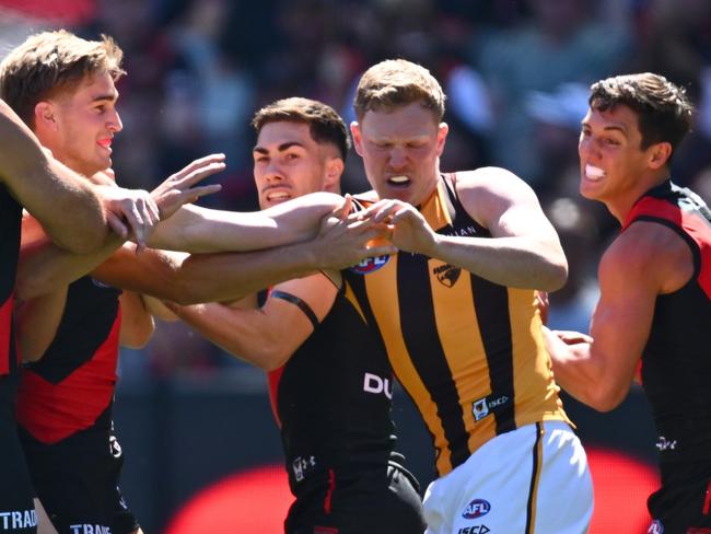 MELBOURNE, AUSTRALIA - MARCH 16: Bombers players remonstrate with James Sicily of the Hawks after he gave away a free kick to Andrew McGrath of the Bombers during the round one AFL match between Essendon Bombers and Hawthorn Hawks at Melbourne Cricket Ground, on March 16, 2024, in Melbourne, Australia. (Photo by Quinn Rooney/Getty Images)