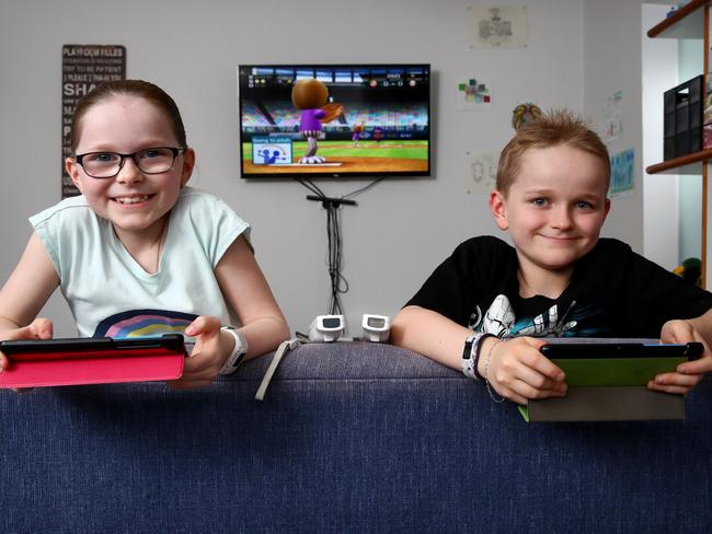 Amber Muir 8 and brother Will 9 pictured at their South Windsor home playing games on their console and tablets. Story on the risks of kids becoming addicted to video games now that children are home in isolation during the coronavirus pandemic. Amber and Will's parents say they don't want them playing violent games or for long periods. Picture: Toby Zerna