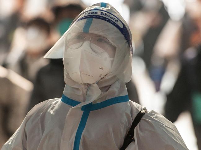 TOPSHOT - This photo taken on December 10, 2022 shows a passenger wearing personal protective equipment (PPE) amid the Covid-19 pandemic arriving at Hankou Railway Station in Wuhan in China's central Hubei province. (Photo by AFP) / China OUT