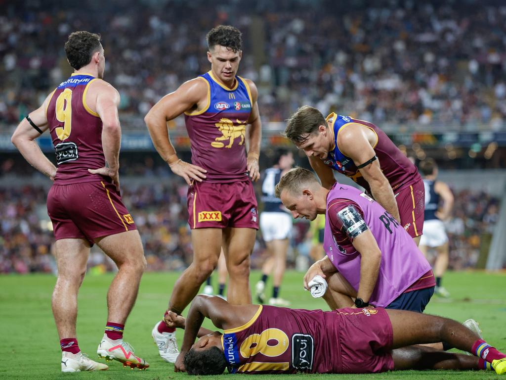 Keidean Coleman lays on the ground injured as his Brisbane teammates Lachie Neale (left), Cam Rayner (centre) and Linc McCarthy try to console him. Picture: Russell Freeman/AFL Photos via Getty Images