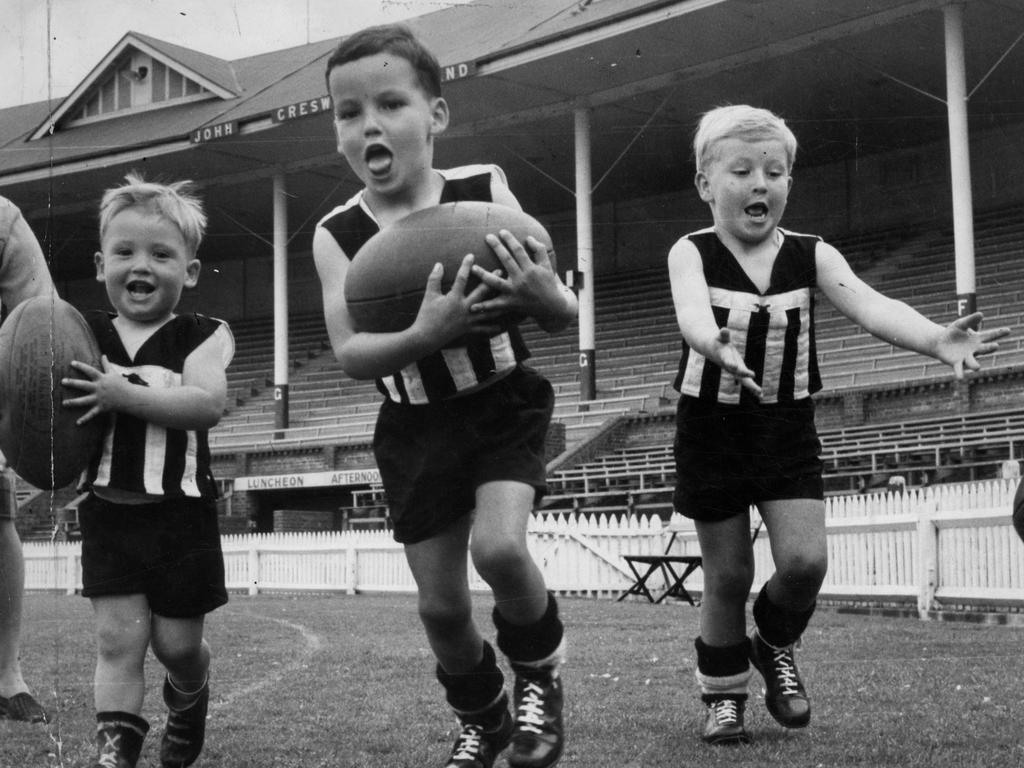 These junior Magpies are staking their claims early for a place in the Port side. Little wonder, they are the sons of Port coach Fos Williams. The children (l-r) Stephen, 2, and twins Mark and Anthony, 5, had the football outfits specially made for them by staunch Port barracker Mrs. A. Dealtry. "The News" 03 Oct 1963.