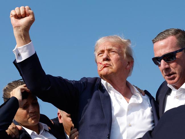 TOPSHOT - BUTLER, PENNSYLVANIA - JULY 13: Republican presidential candidate former President Donald Trump pumps his fist as he is rushed offstage during a rally on July 13, 2024 in Butler, Pennsylvania. Butler County district attorney Richard Goldinger said the shooter is dead after injuring former U.S. President Donald Trump, killing one audience member and injuring another in the shooting.   Anna Moneymaker/Getty Images/AFP (Photo by Anna Moneymaker / GETTY IMAGES NORTH AMERICA / Getty Images via AFP)