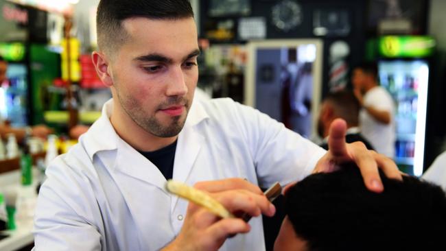 Bill Kandakji, 22, hard at work in the barber shop. Picture: Angelo Velardo