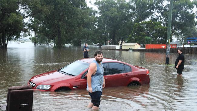 Residents tackle floodwaters at Church Street in Windsor, to the west of Sydney. Picture: John Feder/The Australian