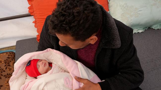 Khalil al-Suwadi holds his niece Afraa who will now live with his wife and kids. Picture: AFP