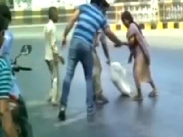 CREDIT: YouTube Residents in Gujarat struggled to get across the road after their feet kept sticking to the surface. One man is forced to leave his shoe behind after it gets glued to the road at the same moment a car approaches. Another woman carrying a heavy bag on her head falls face first after both her feet get completely stuck in the tar.