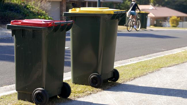 Two rubbish bins in Australia. Red lid is rubbish, yellow lid is recycling.