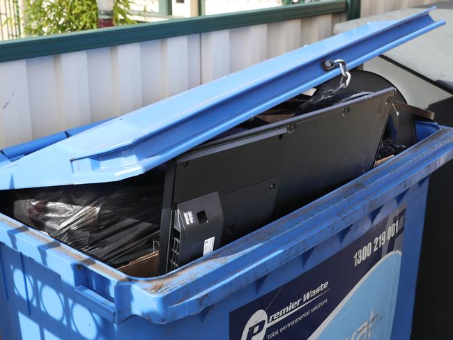 A smashed TV in a bin outside the house. Picture: David Crosling