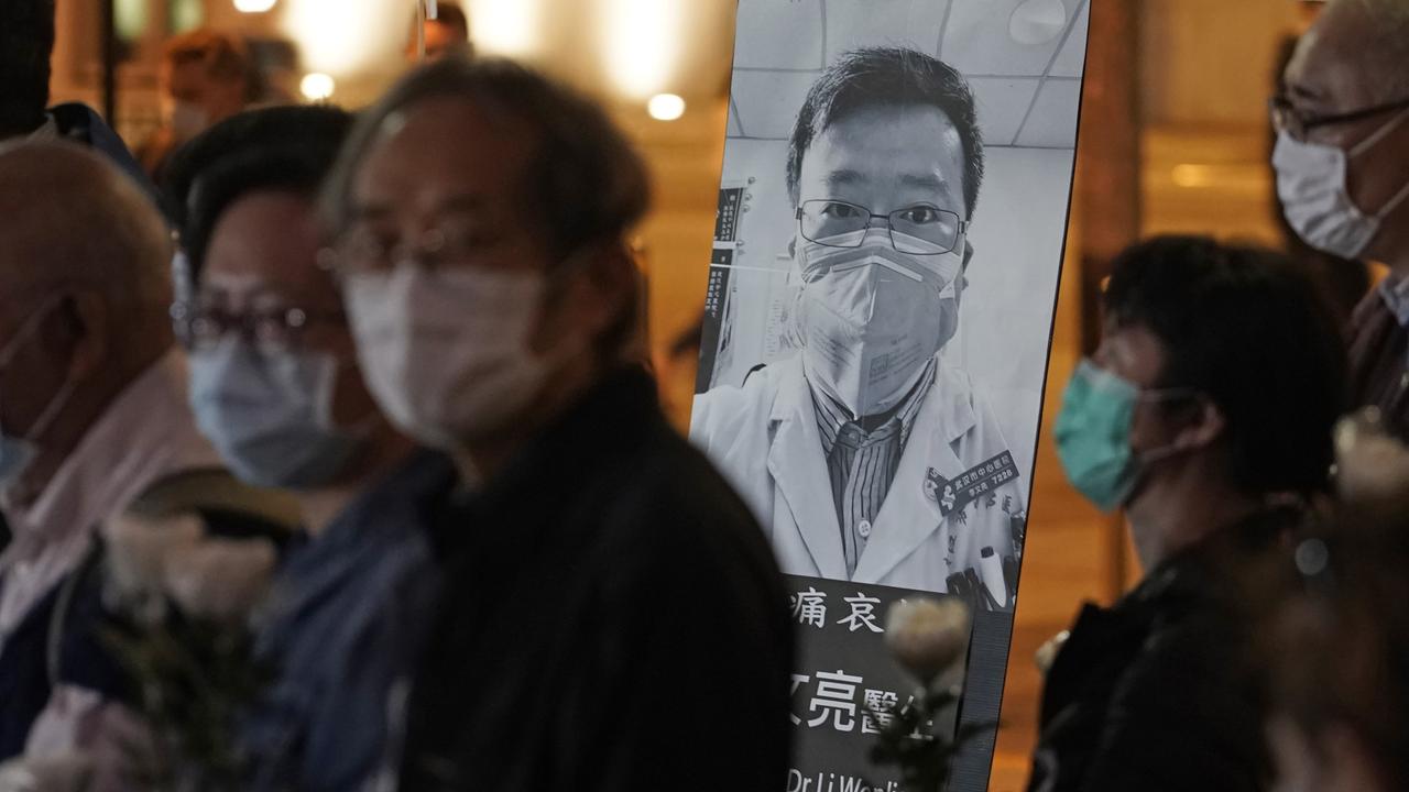 People wearing masks, attend a vigil for Chinese doctor Li Wenliang in Hong Kong on Friday. Picture: AP Photo/Kin Cheung