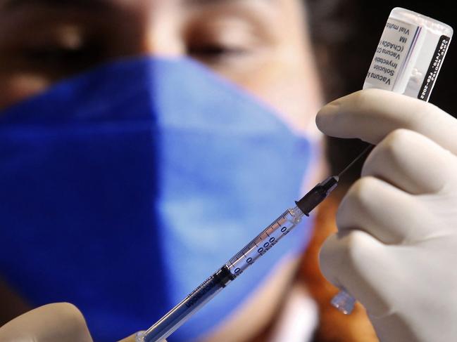 A nurse prepares a booster dose of the AstraZeneca's COVID-19 vaccine for people over 50 years old at a vaccination center set up at the Benito Juarez Auditorium in Zapopan, state of Jalisco, Mexico, on January 24, 2022. (Photo by ULISES RUIZ / AFP)