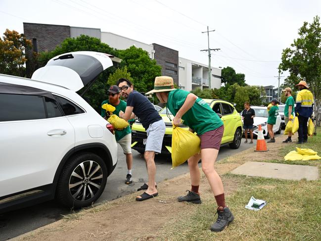 BRISBANE, AUSTRALIA - MARCH 05: Volunteers help load sandbags into residents' cars at a Morningside sandbag depot on March 05, 2025 in Brisbane, Australia. Tropical Cyclone Alfred is expected to make landfall in southeast Queensland and northern NSW as a Category 2 storm, marking the first time a cyclone has directly hit the region in over 50 years. The storm is forecast to bring damaging winds, heavy rainfall, and potential storm surges, prompting authorities to urge residents to prepare for significant impacts, including flooding and power outages. (Photo by Albert Perez/Getty Images)