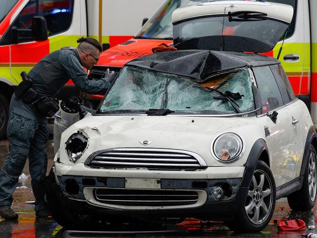 TOPSHOT - A police officer works at the scene where a car drove into a crowd in the southern German city of Munich on February 13, 2025 leaving several people injured, police said. Munich police said on social media platform X that "several people were injured" after "a car drove into a group of people" in the centre of the Bavarian state capital. (Photo by Michaela STACHE / AFP) / ALTERNATIVE CROP