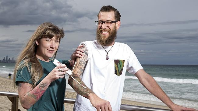 Danielle Chisholm and Ricky Leslie trying the The Original Sin sunscreen designed for people with tattoos. Photo: Jerad Williams