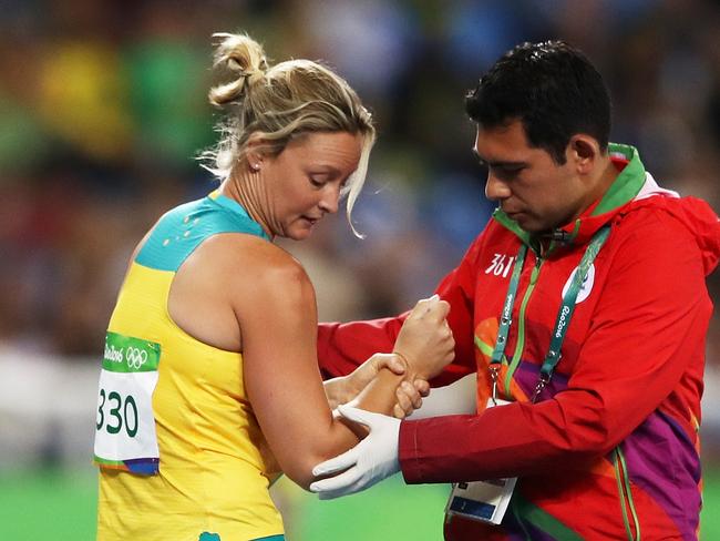 Kim Mickle of Australia is assisted by medical staff after being injured during the Women's Javelin