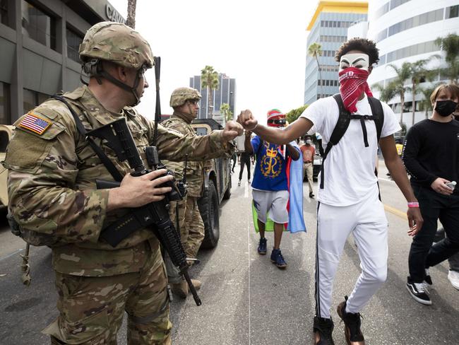 A demonstrator fist bumps a member of the National Guard in Los Angeles, California. Picture: Brent Stirton/