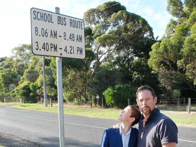 Connewarre dad Daniel Timms wants the school bus his son uses to be able to use te safer School bus Route on Bluestone School Road which is used by other school buses instead of the 100 kmh Barwon Heads Road which his son is forced to use . Daniel Timms  with his son Charles under the school bus route sign on Bluestone school Rd. Picture: Mark Wilson