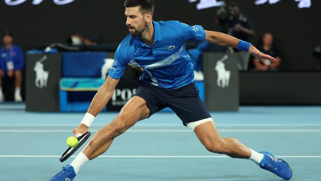 MELBOURNE, AUSTRALIA - JANUARY 21: Novak Djokovic of Serbia plays a backhand against Carlos Alcaraz of Spain in the Men's Singles Quarterfinal match during day 10 of the 2025 Australian Open at Melbourne Park on January 21, 2025 in Melbourne, Australia. (Photo by Clive Brunskill/Getty Images)